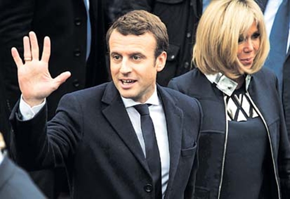 French presidential election candidate for the En Marche ! movement Emmanuel Macron waves to supporters next to his wife Brigitte Trogneux on May 7, 2017, in Le Touquet, northern France, after voting for the second round of the French presidential election. / AFP PHOTO / PHILIPPE HUGUEN