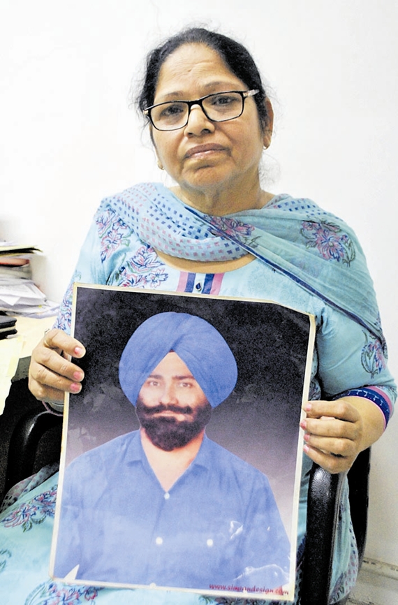 Paramjit Kaur showing the picture of her husband who went missing in year 1992 after some policemen picked him up from his residence in Amritsar .photo Sunil kumar